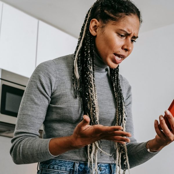 woman frowning while holding a smartphone