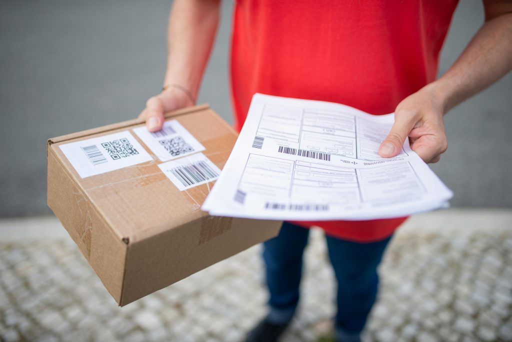 delivery worker holding a parcel and shipping forms