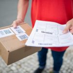 delivery worker holding a parcel and shipping forms