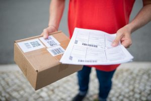 delivery worker holding a parcel and shipping forms